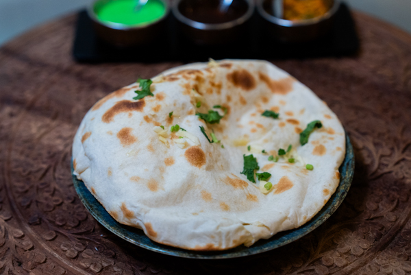 Garlic Nan Fromage, pain naan cuit au four tandoor par le Kashmir Café à Montreuil